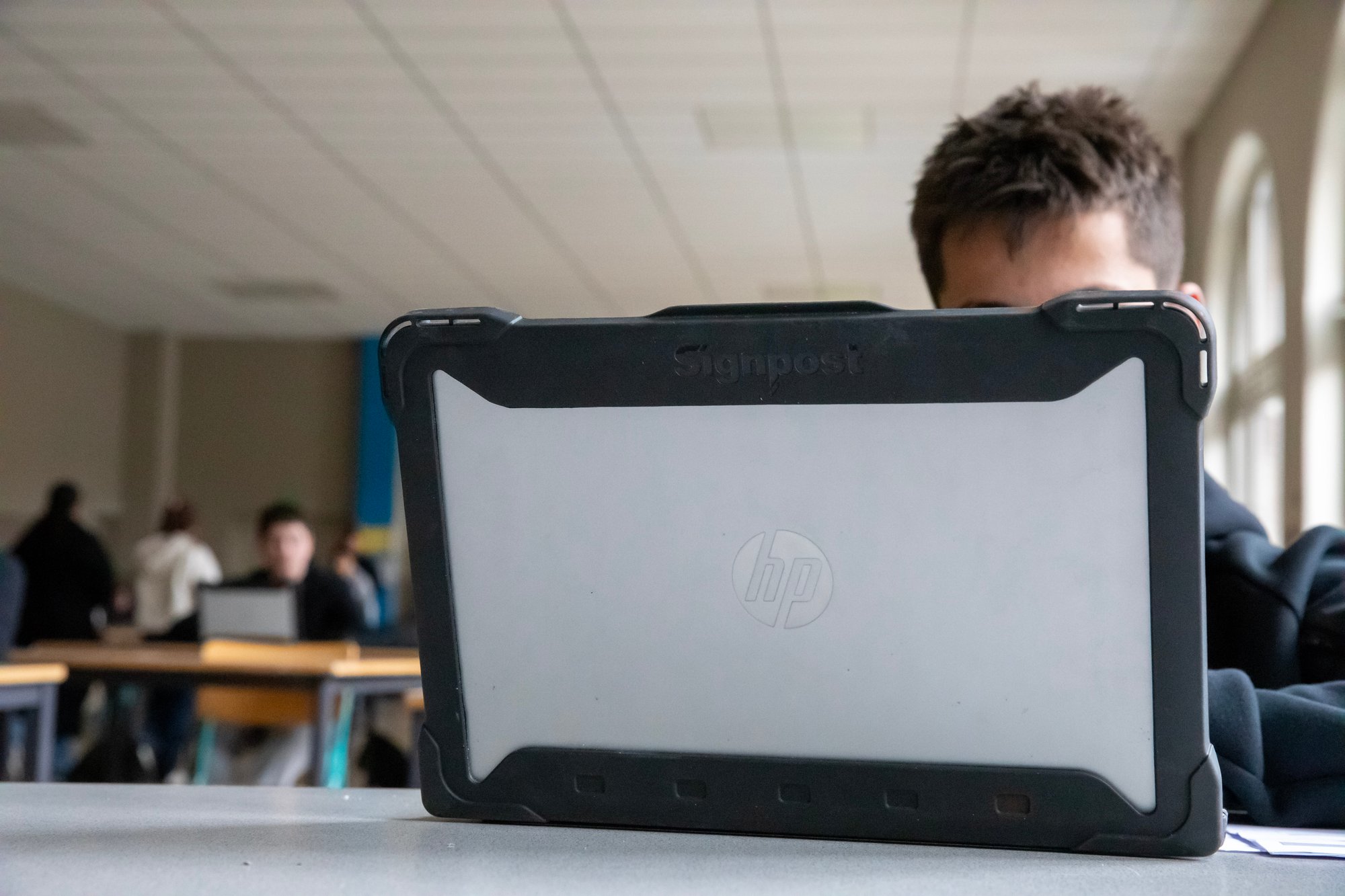 Leerkracht die een les voorbereid op een HP laptop met Signpost Shockcase
